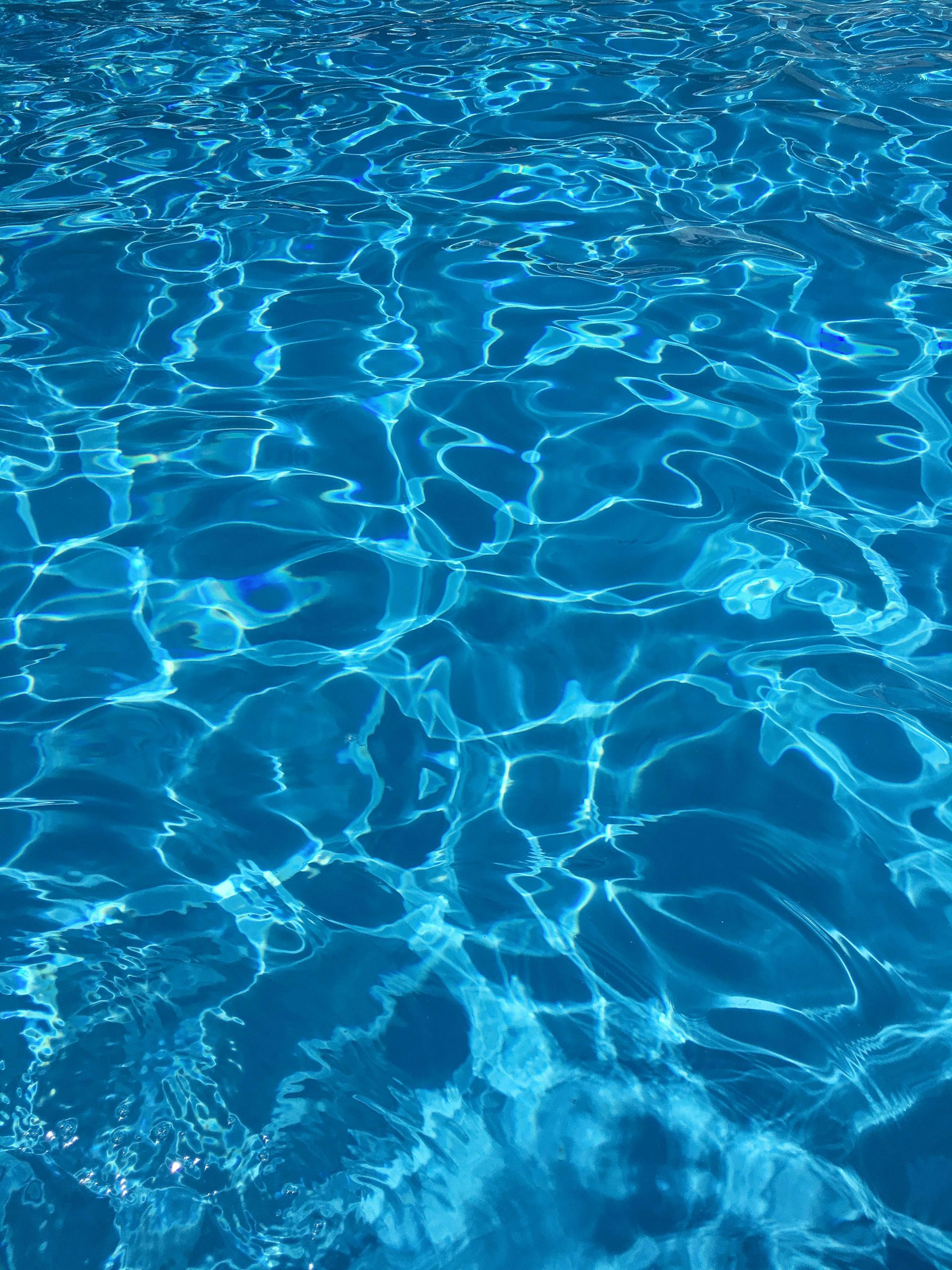 Vibrant blue swimming pool water with dynamic reflections, ideal for abstract backgrounds.